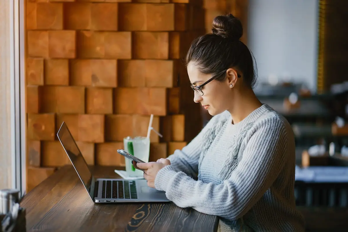 Woman working on a laptop at a restaurant table